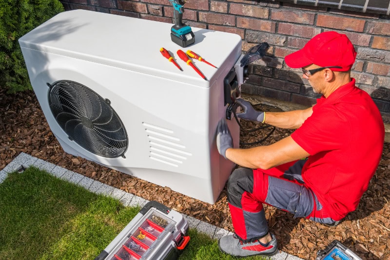 A handyman installing a new heat pump system