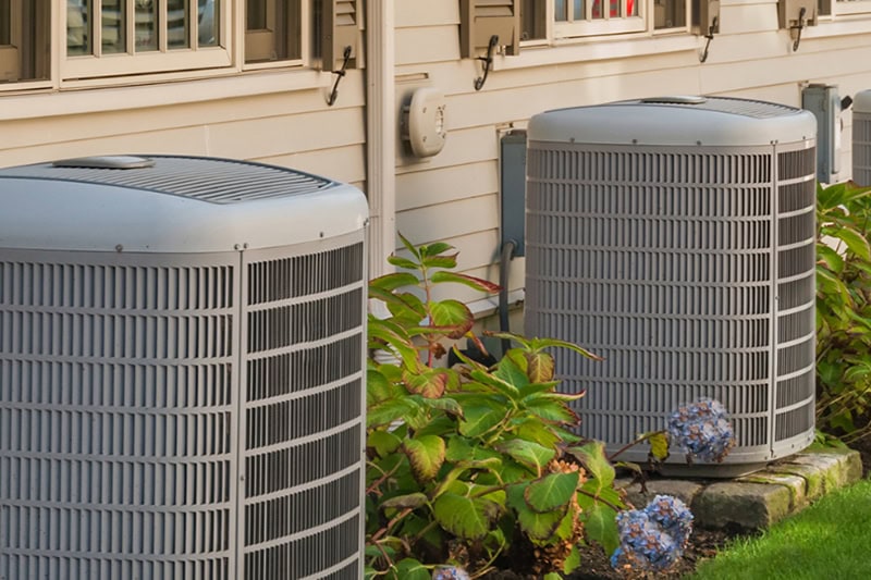 5 Signs Your AC Needs Repair Before Summer Hits. Photo of two AC units installed outside of a home.